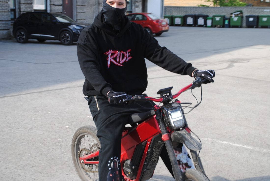 Rider on an electric bike in a printed hoodie